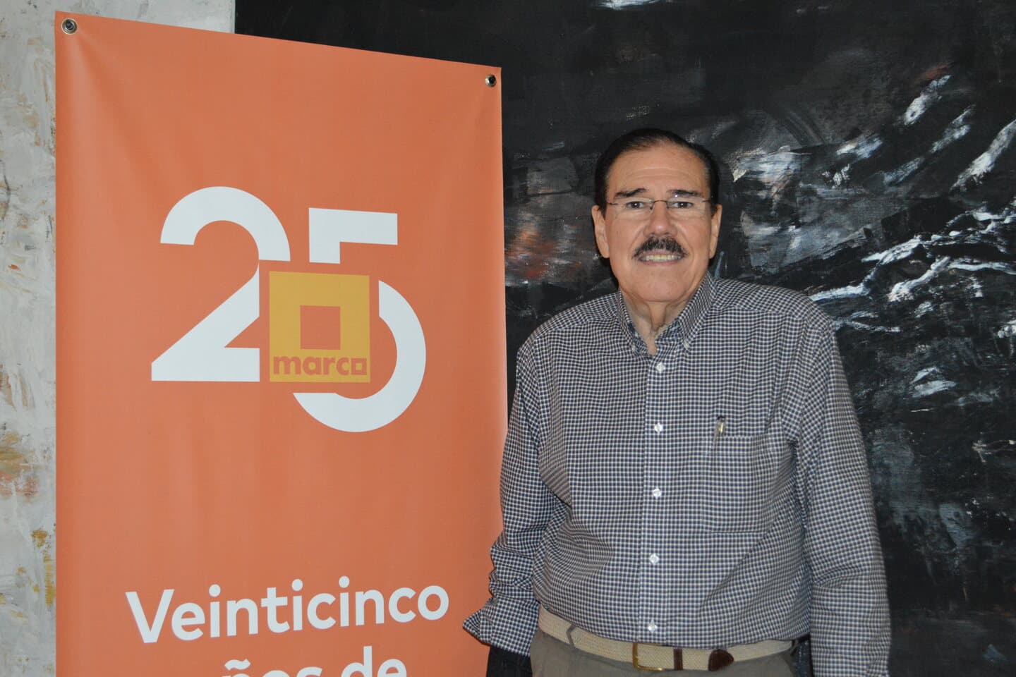 Fidel Chávez Pérez junto a un distintivo conmemorativo de MARCO