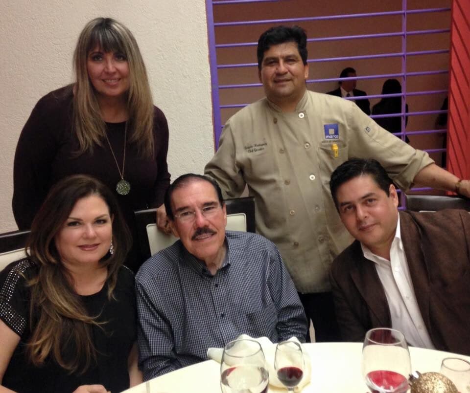 Fidel Chávez Pérez sentado a una mesa acompañado por familiares