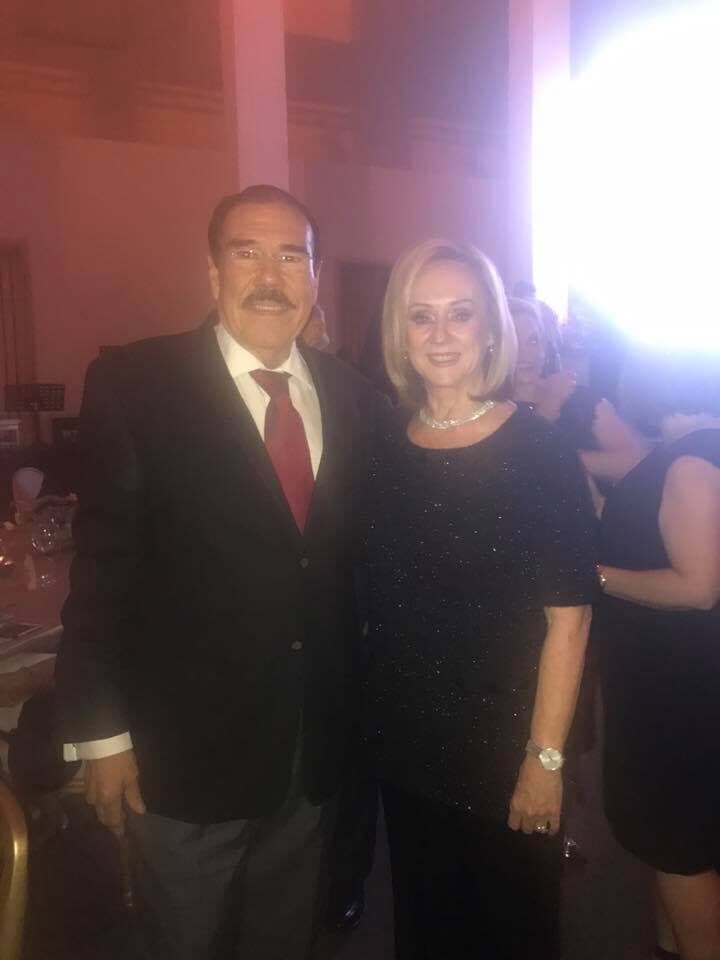 Fidel Chávez Pérez de traje junto a una acompañante en un evento