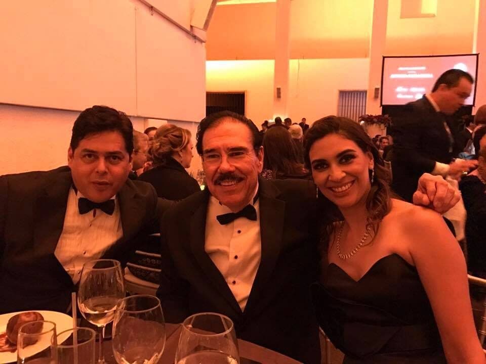 Fidel Chávez Pérez de esmoquin en una cena con dos acompañantes