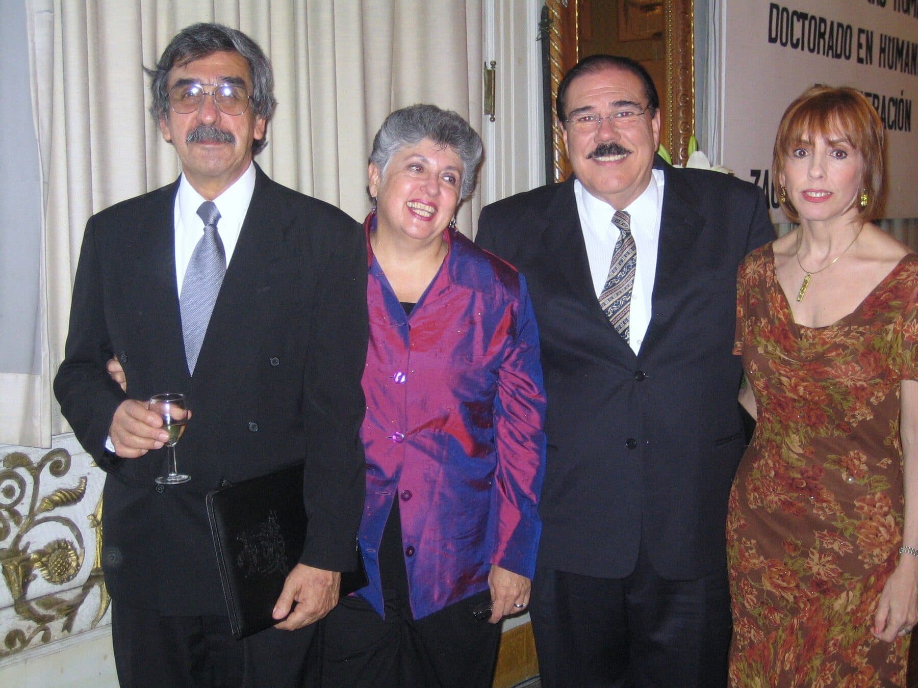 Fidel Chávez Pérez en un evento formal con tres acompañantes